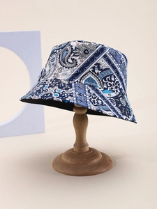 Detailed view of the paisley bucket hat's fabric texture on a wooden stand