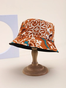 Detailed view of bucket hat featuring vibrant orange and white baroque pattern on a stand