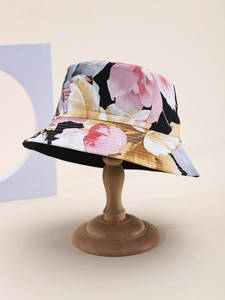 Detail of floral bucket hat showing pink flower prints on black fabric with wood stand