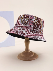 Detail of floral paisley bucket hat with burgundy and purple prints on a wooden stand