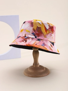 Detail shot of the floral print bucket hat with pink abstract patterns on a wooden stand