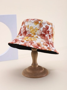 Detailed macro view of the leaf print sun hat fabric on a wooden display stand