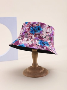 Détail d'un chapeau bob à motifs floraux abstraits sur un support en bois violet et bleu