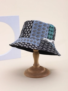 Détail d'un chapeau bob en patchwork avec motifs floraux et géométriques sur support bois