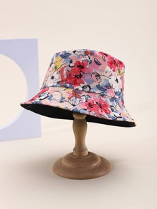 Détail d'un chapeau bob à motif floral coloré avec doublure noire sur un support bois