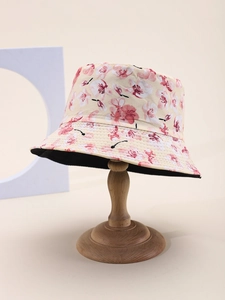 Dettaglio cappello da pescatore con fiori di ciliegio su supporto di legno naturale