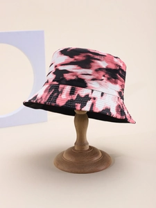 Detail of pink and black tie-dye cotton bucket hat displayed on a wooden stand