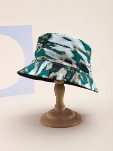 Detailed close-up of a tie-dye bucket hat with parallel stitching on a wooden stand
