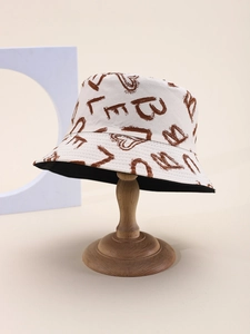 Détail d'un chapeau bob réversible avec motifs de lettres et cœurs sur support en bois