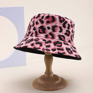 Pink leopard print bucket hat on wooden stand for outdoor sun protection and stylish wear