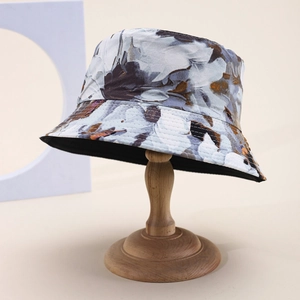 Double-sided bucket hat featuring blue ink floral tie-dye pattern and black lining