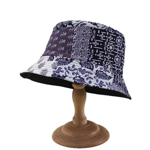 Chapeau bob réversible style bohème avec motifs floraux sur support en bois naturel