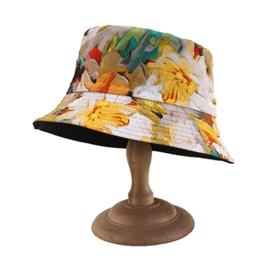 Floral print sun bucket hat with colorful oil painting pattern on a wooden display stand