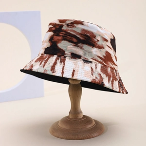 Double-sided tie-dye bucket hat with abstract marble print on a wooden display stand