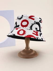 Detail of artistic graffiti print bucket hat with bold red, white, and black lettering