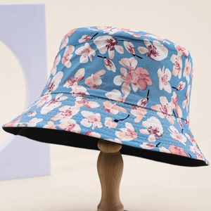 Cappello a secchiello in cotone da donna con fiori azzurri su supporto in legno