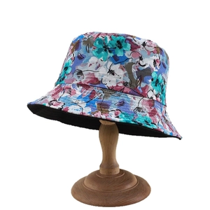 Bob réversible à motif floral bleu et rose présenté sur un support à chapeau en bois