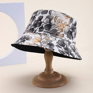 Detailed close-up of patterned bucket hat with grey and gold leaf prints on high-quality fabric