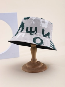 Detail of canvas bucket hat featuring graffiti letter print on vintage wood stand