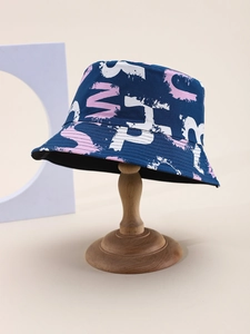 Close-up detail of graffiti alphabet print on navy blue bucket hat with visible stitching