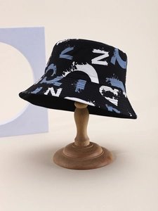 Close-up of black graffiti bucket hat with blue and white lettering on wood stand