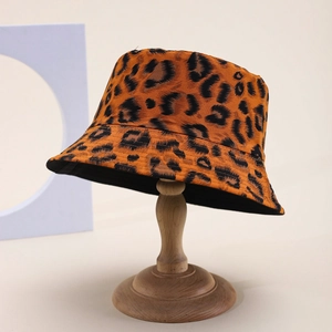 Classic leopard print bucket hat on wooden display stand in a minimalist studio setting