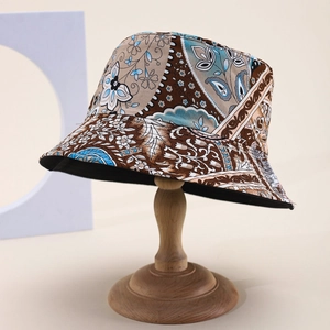 Detail of bohemian patchwork bucket hat with paisley floral patterns on a wooden stand