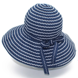 Detail of navy blue striped sun hat featuring a large brim and a stylish ribbon bow