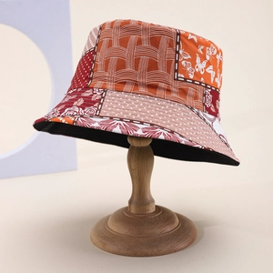 Detail of multi-pattern patchwork bucket hat with floral and butterfly prints on hat stand