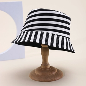 Detailed view of black and white striped bucket hat on a wooden display stand