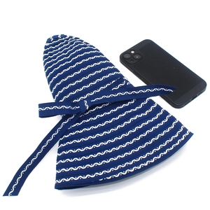 Foldable striped sun hat with bow tie shown next to a smartphone for size comparison