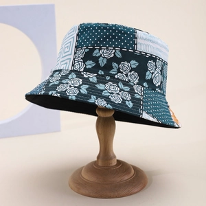 Close-up of patterned bucket hat with floral and polka dot patchwork on a wooden stand