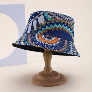Detailed close-up of a bucket hat with ethnic geometric patterns on a wooden display stand