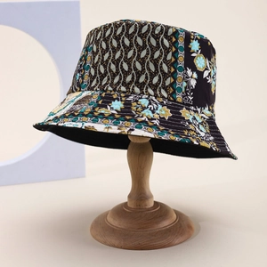 Detail view of patchwork fisherman hat with floral and geometric patterns on a wooden stand