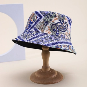 Close-up of a vintage paisley bucket hat featuring intricate bohemian patterns on a wooden stand