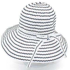 White striped wide brim sun hat with black wave patterns and a decorative side bow