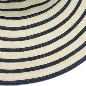Close-up of woven straw sun hat brim with fine beige texture and black stripes