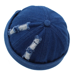 Close-up of distressed denim skull cap showing worn-out details and blue texture