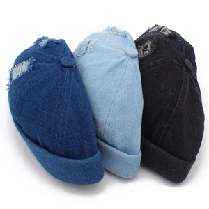Detailed macro view of distressed denim docker hats in navy blue, light blue, and black colors