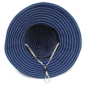Close-up of a wide-brim sun hat with blue wave patterns and adjustable chin strap