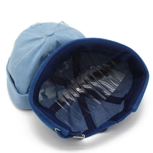 Detail of blue denim melon caps showing metal buckle adjustment and inner lining