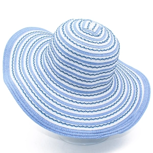 Detail of blue and white striped pattern on wide brim woven straw sun hat for women
