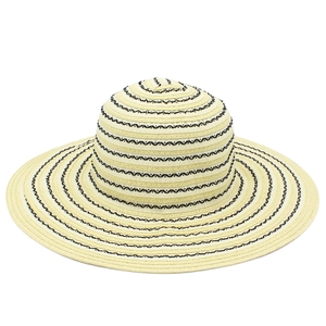 Detail of beige straw hat with black wavy woven stripes and wide sun protection brim