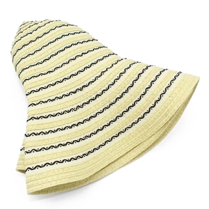 Detail showing woven straw texture and black wavy patterns on the wide brim sun hat