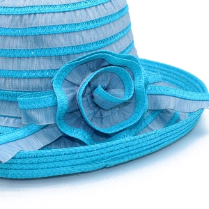Detail of blue striped sun hat featuring a handcrafted fabric flower and woven texture