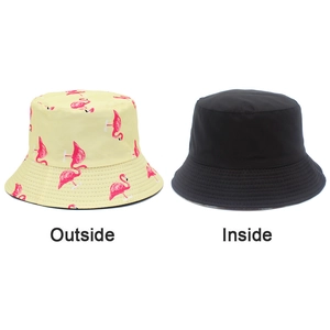 Dual-sided bucket hat with pink flamingo print on yellow and solid black reverse side