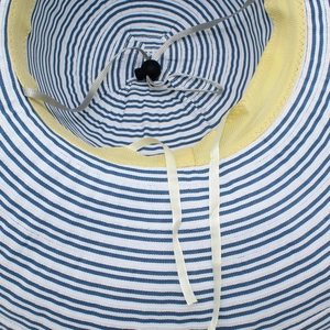 Detailed interior of striped sun hat showing sweatband and adjustable wind rope