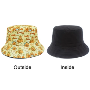 Detailed view of reversible bucket hat showing yellow capybara print and plain black lining