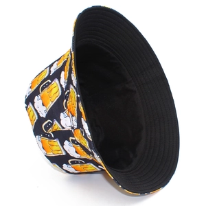 Détail d'un bob noir avec motifs de bopes de bière jaunes et doublure intérieure noire