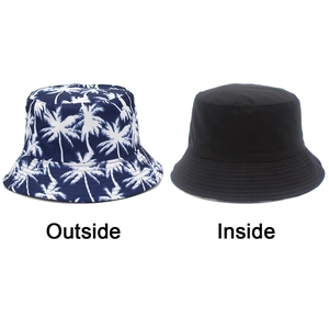 Close-up of double-sided bucket hat showing tropical palm print and solid black lining